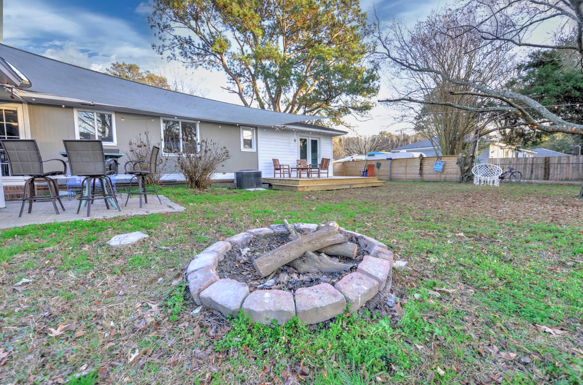 Stone fire pit on a paver patio behind the house at golden hour